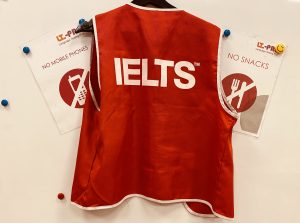 A photograph of the test administrators' bib at an IELTS IDP test centre